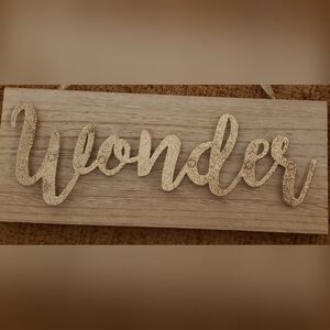 "WONDER" Wall Art. Gold Sparkle Lettering on simulated wood base.